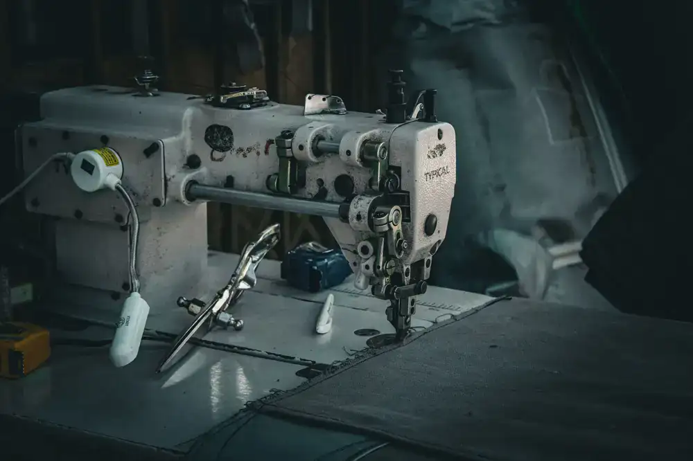 Technician sewing heavy-duty technical fabric on an industrial machine