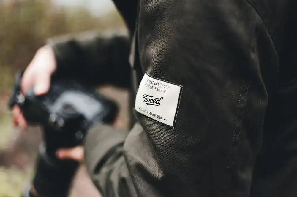 Finished durable patch repair on the shoulder of an outdoor shell jacket